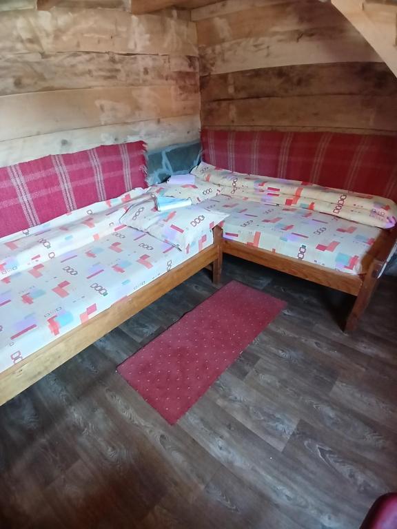 a couple of beds in a room with a table at Dulović - KATUN POTOCI in Kolašin