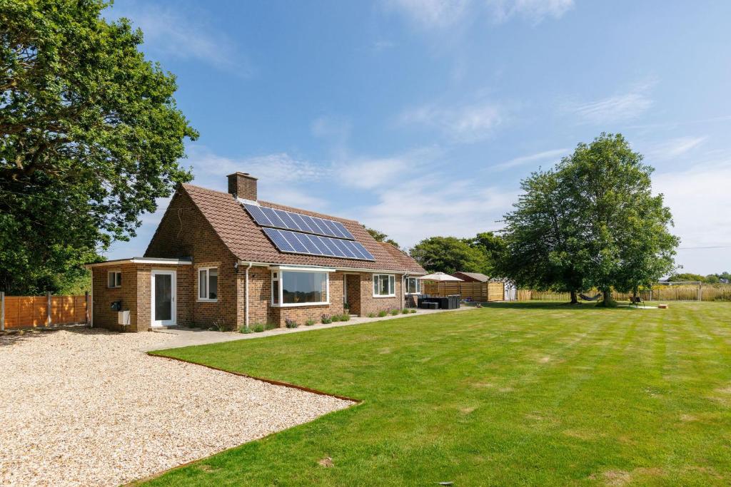 a house with solar panels on the roof at Idyllic 3 Bed Country Cottage in West Wittering