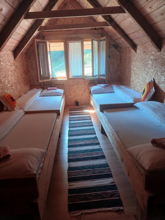 a room with four beds in it with windows at Dulović - KATUN POTOCI in Kolašin