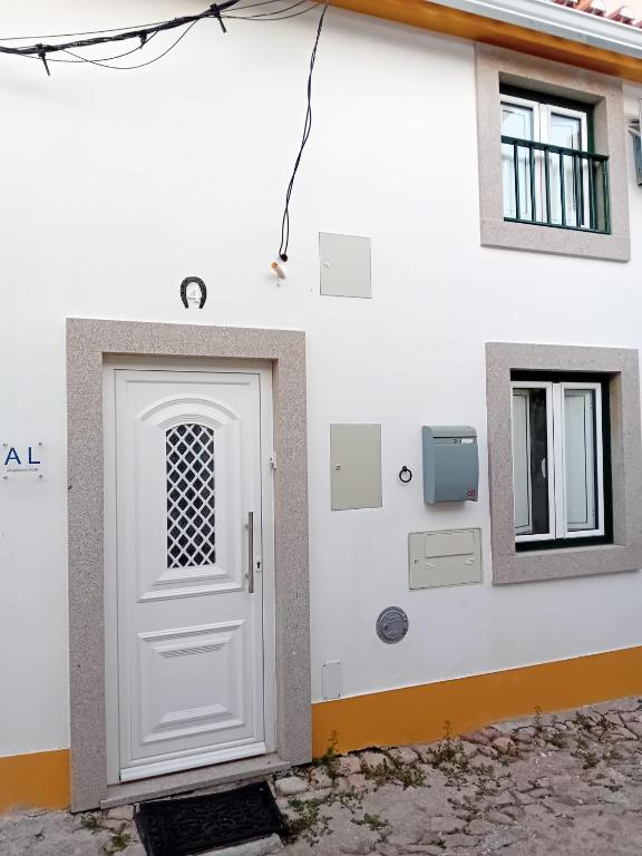 a white door on the side of a building at Casa Madureira in Alpalhão