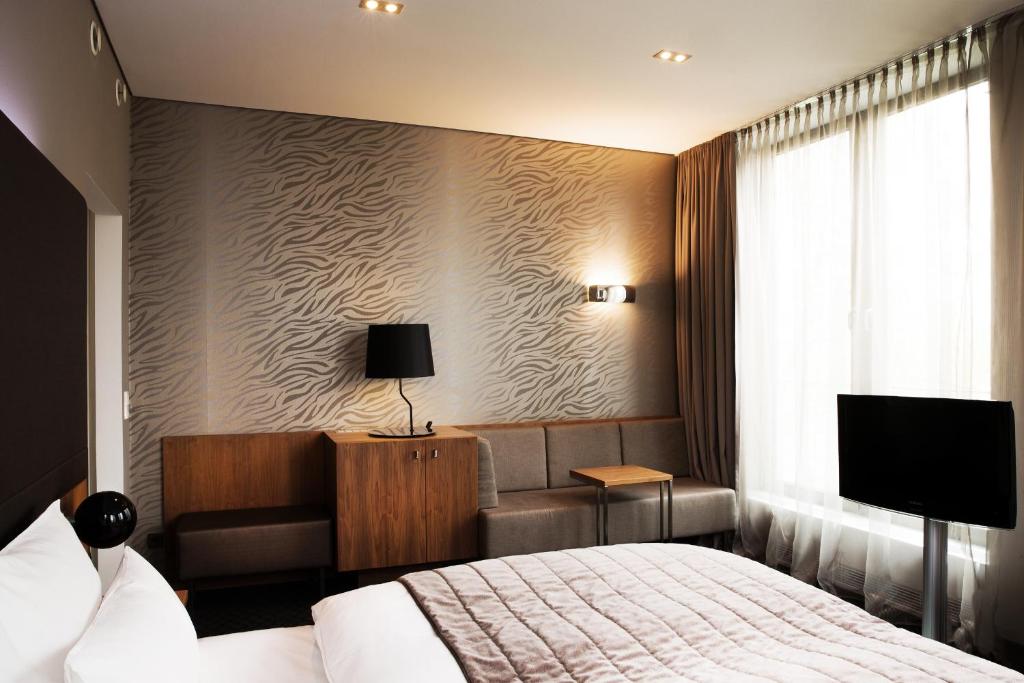 Postel nebo postele na pokoji v ubytování COSMO Hotel Berlin Mitte