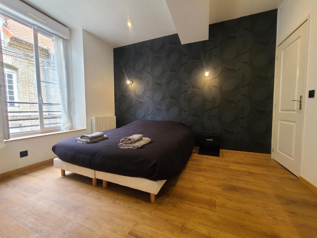 une chambre avec un lit avec un mur noir dans l'établissement Le Rivage Ébène & Distinction, à Dieppe