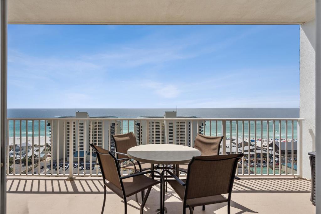 a balcony with a table and chairs and a view of the ocean at Stunning Gulf View Condo - Direct Beach Access - Stunning Sunsets in Panama City Beach
