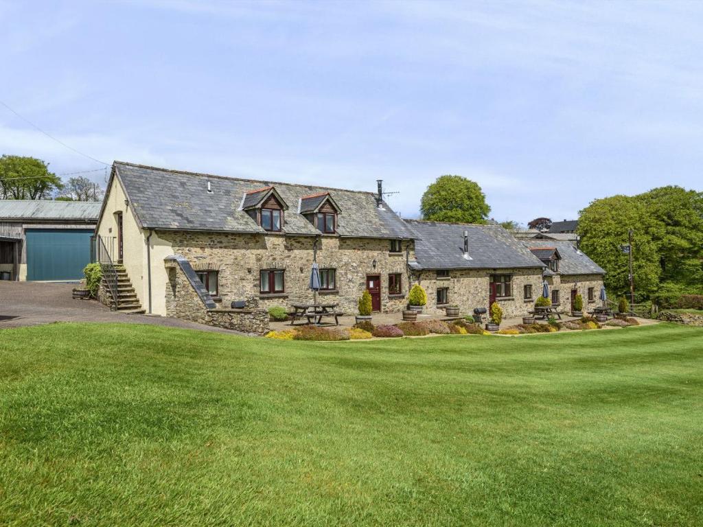 a large stone house with a large yard at Kiri - Charming Cottage Perfect for Large Groups & Family in Dulverton