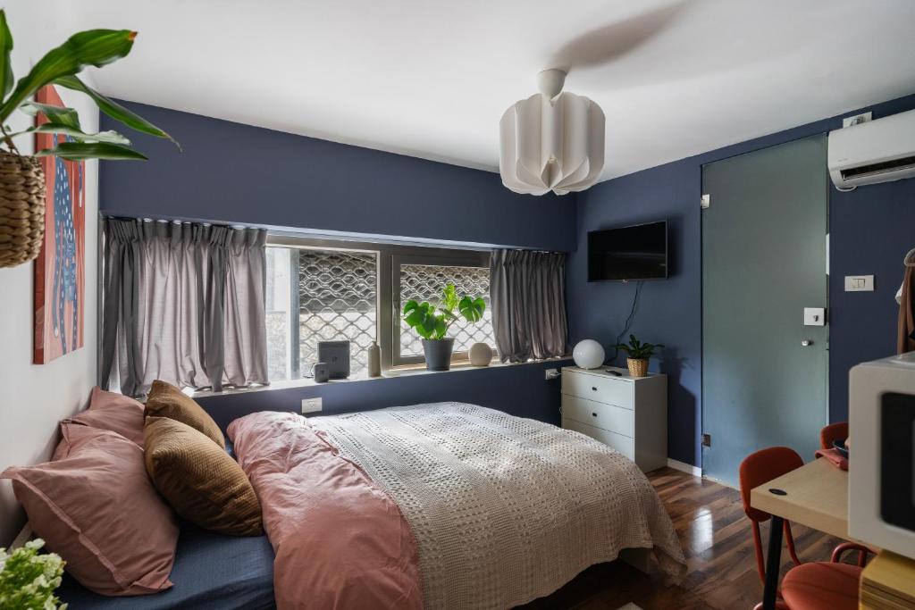 a bedroom with blue walls and a bed at Dotan's Boutique Studios - By Gordon Beach! in Tel Aviv