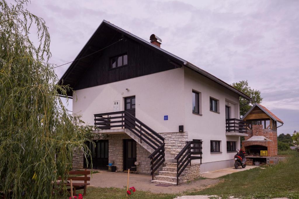 una gran casa blanca con techo negro en Apartment VI&MI, en Slunj