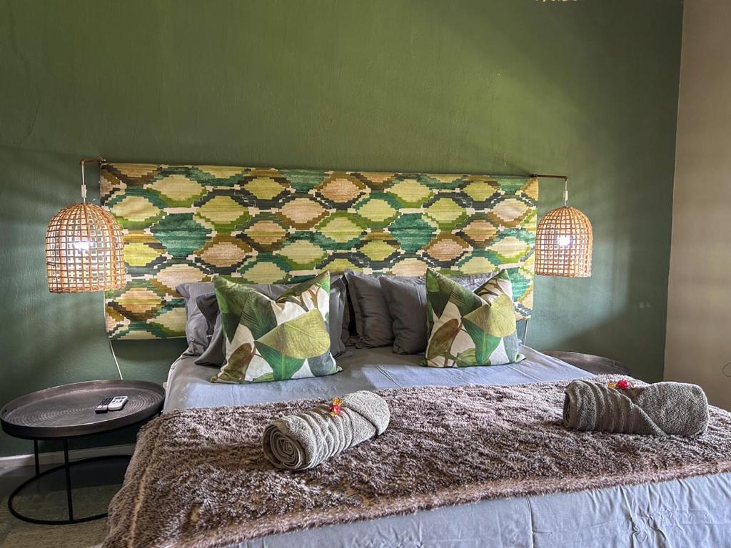 a bedroom with a large bed with a green wall at Tzamenkomst River Lodge in Colesberg