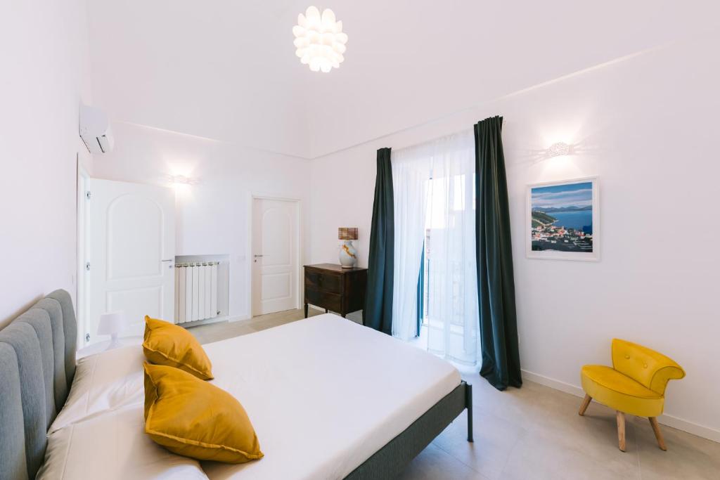 una camera con letto e sedia gialla di Casa Don Matteo a Scala