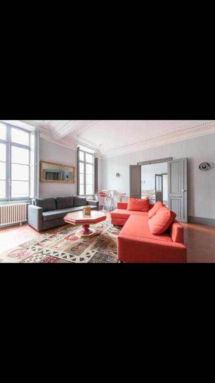 un salon avec un canapé rouge et une table dans l'établissement Beziers centre historique, à Béziers