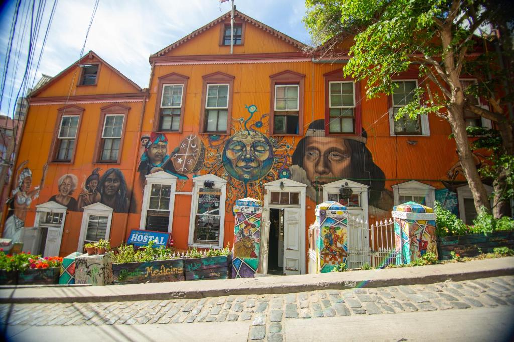 an orange building with a mural on the side of it at La Casa Del Puerto, Hostal cultural, Cerro Alegre in Valparaíso