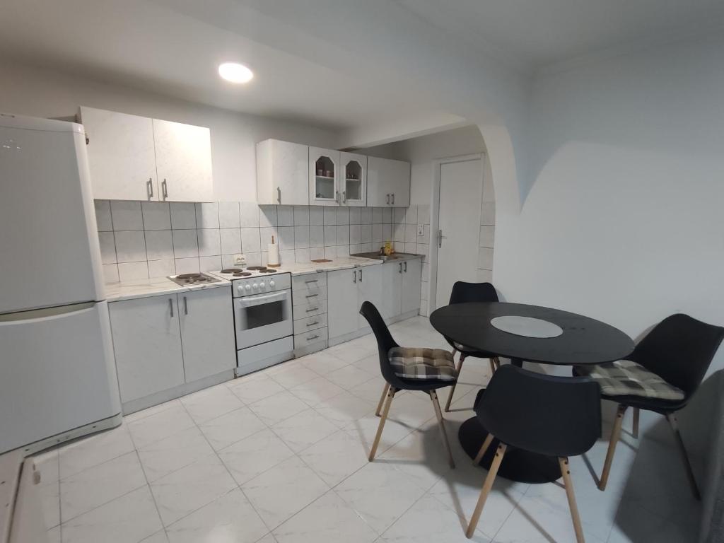 una pequeña cocina con mesa y sillas. en Esma, en Sarajevo