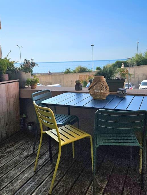 une table, deux chaises, une table et des chaises dans l'établissement appartement terrasse vue mer, à Sète