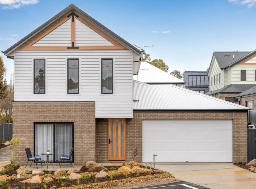 una casa con un garaje blanco delante de ella en Brand new 3 bed townhouse walk to town, en Beechworth