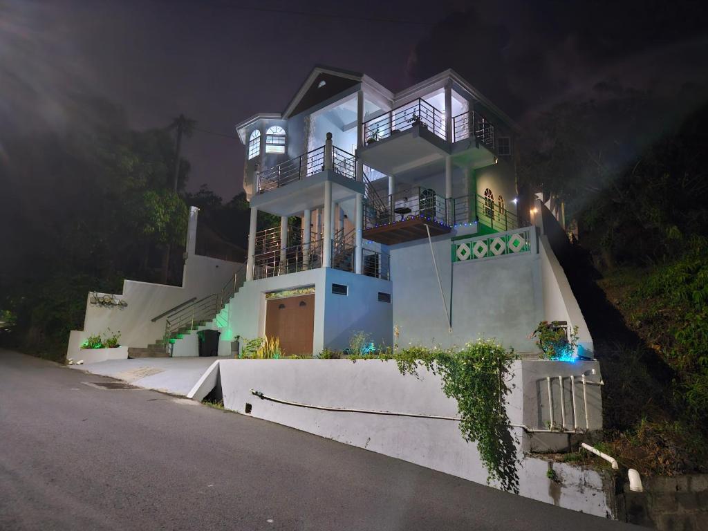 una grande casa bianca su una collina di notte di La Bwizan Apt # 2 a Laborie