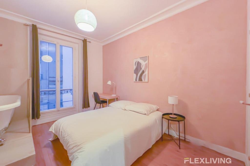 une chambre avec un lit, un bureau et une fenêtre dans l'établissement Flexliving - room - Neuilly-sur-Seine, à Neuilly-sur-Seine