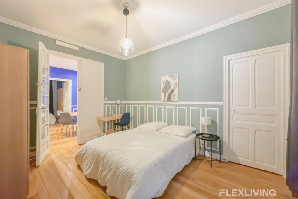 une chambre avec un lit, une table et des chaises dans l'établissement Flexliving - room - Neuilly-sur-Seine, à Neuilly-sur-Seine