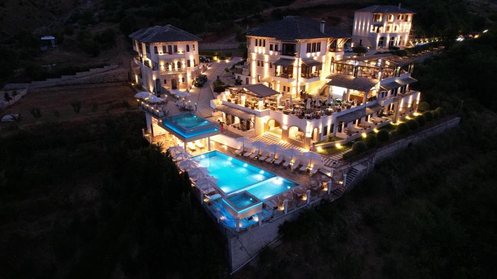 an aerial view of a mansion with a swimming pool at night at KERCULLA Resort in Gjirokastër