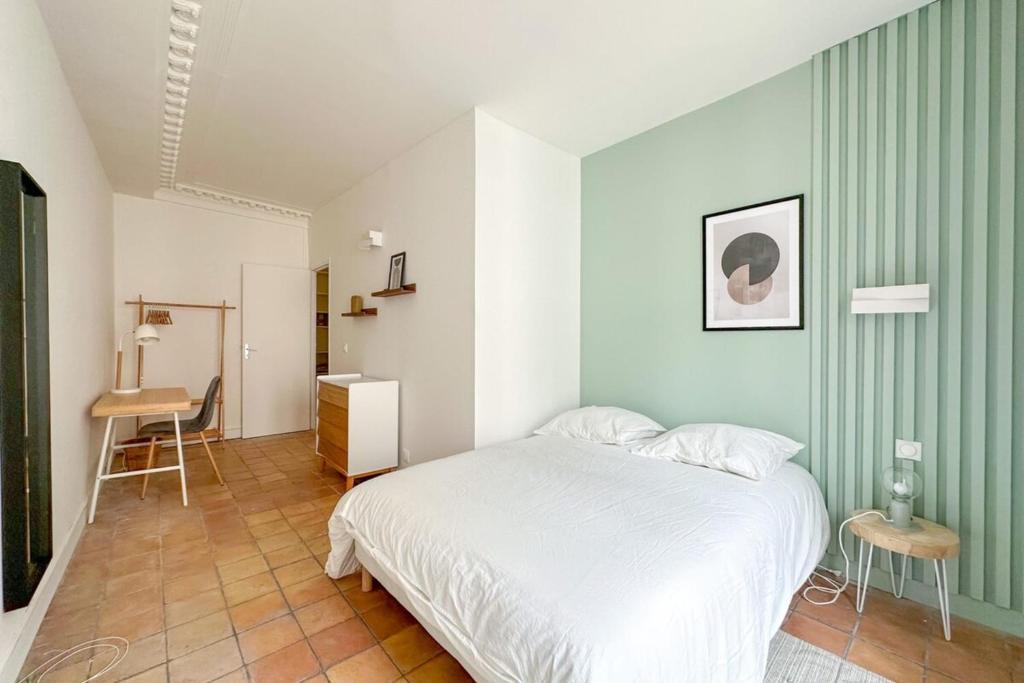 une chambre avec un lit blanc et un mur vert dans l'établissement Flexliving - room - Echiquier, à Paris