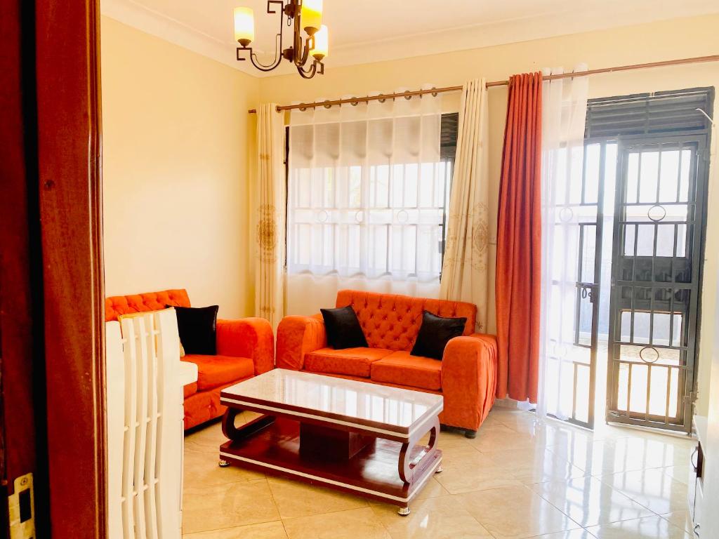 a living room with an orange couch and a coffee table at Rose Pearl Apartment in Entebbe