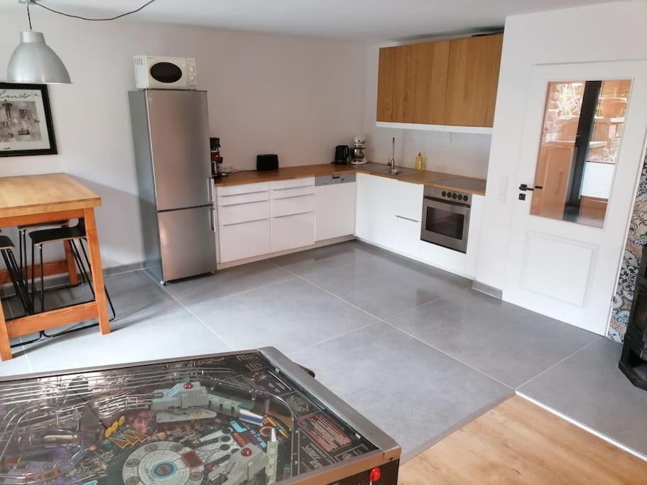 a kitchen with white cabinets and a stainless steel refrigerator at Gemütliche Wohnung Rothaarsteig Ski Sauna Ruhrtal Green Hill in Schmallenberg