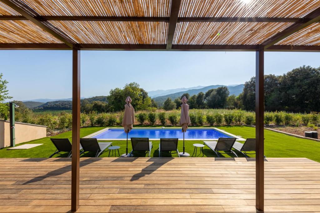 un patio avec des chaises et une piscine sur le toit dans l'établissement Villa avec piscine, à Ghisonaccia