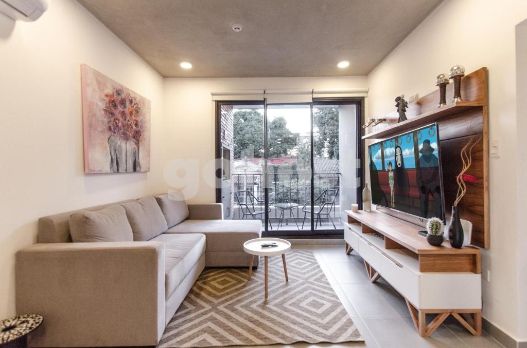 a living room with a couch and a tv at Distinguished And Elegant Apartment 2 Bedroom in Asuncion