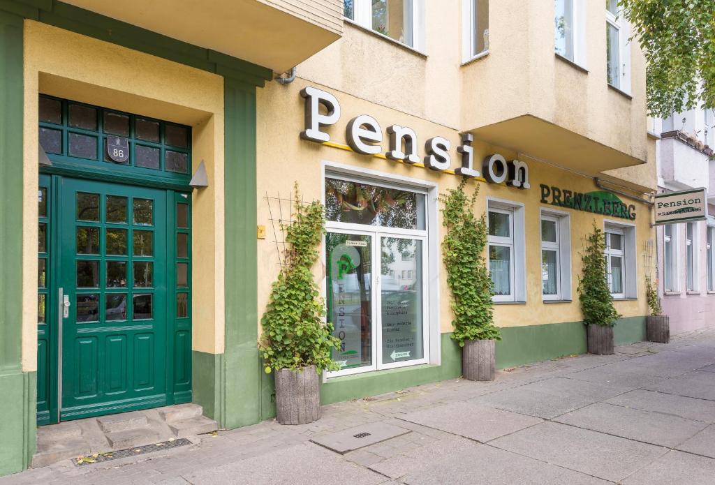 restauracja z zielonymi drzwiami na ulicy w obiekcie Pension Prenzlberg w Berlinie