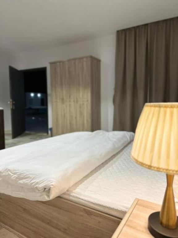 a bed in a room with a lamp and a bed sidx sidx sidx at Studio overlooking pool amid flowering and quiet in Al-ʿUla