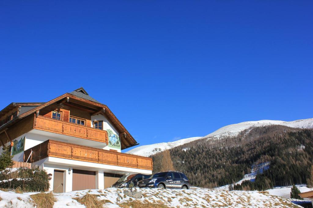 a chalet in the snow with a car parked in front at Stoanock Diamant in Bad Kleinkirchheim