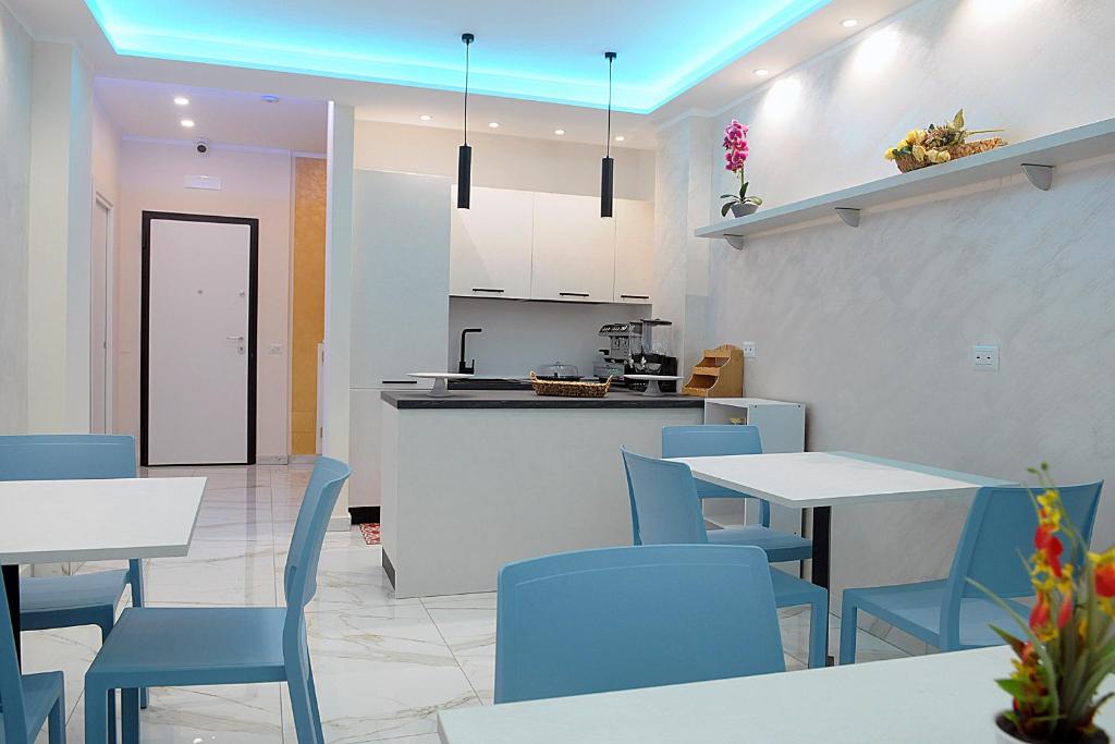 cocina y comedor con sillas y mesas azules en B&B AIDA Rooms Cefalù, en Cefalú