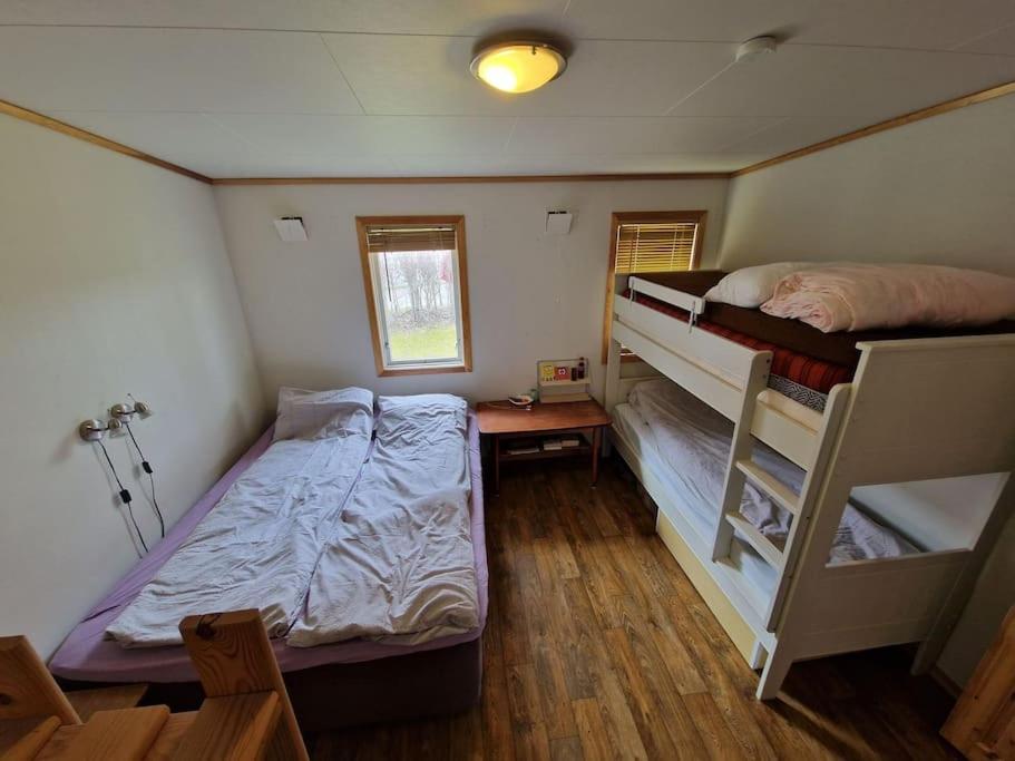 a bedroom with two bunk beds and a window at Feriehus ved fjorden i Solvorn in Luster