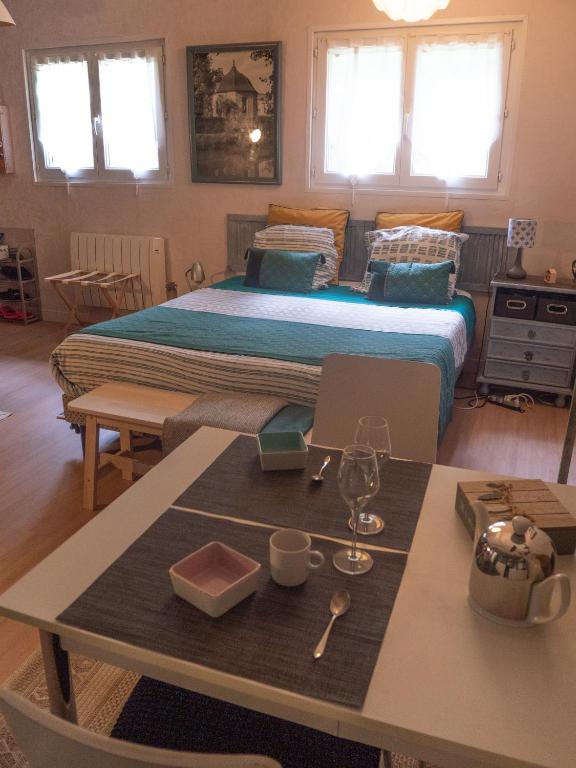 une chambre avec un grand lit et une table avec une table sidx sidx dans l'établissement Chambre d'hôtes au calme avec spa, à Nérac