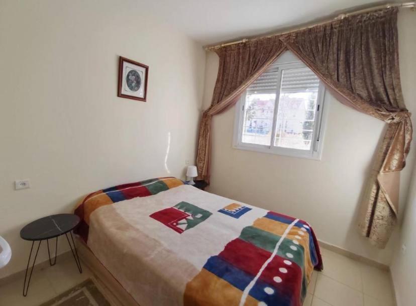 a small bedroom with a bed and a window at Appartement Luxury Comfort in Fès