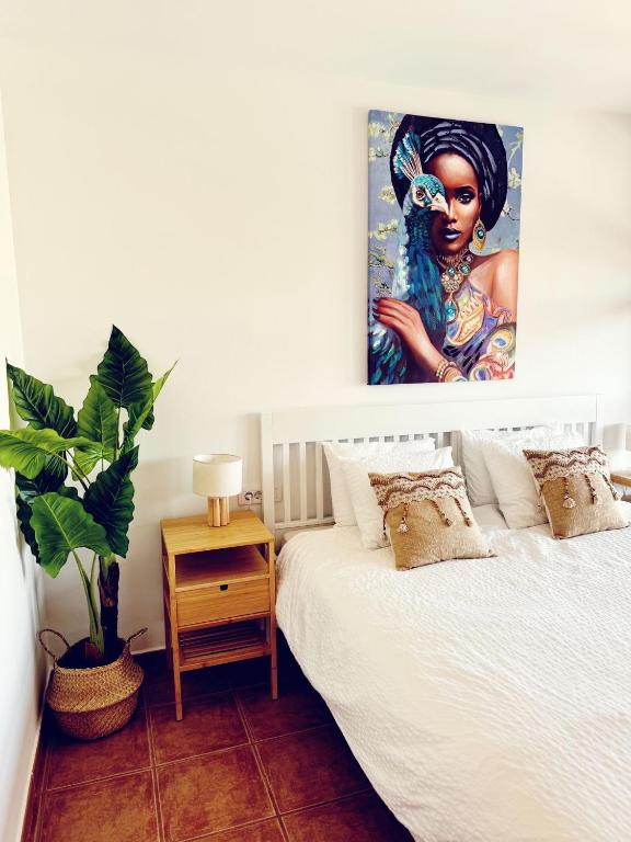 a bedroom with a bed with a painting on the wall at Take It EaSea in San Miguel de Abona