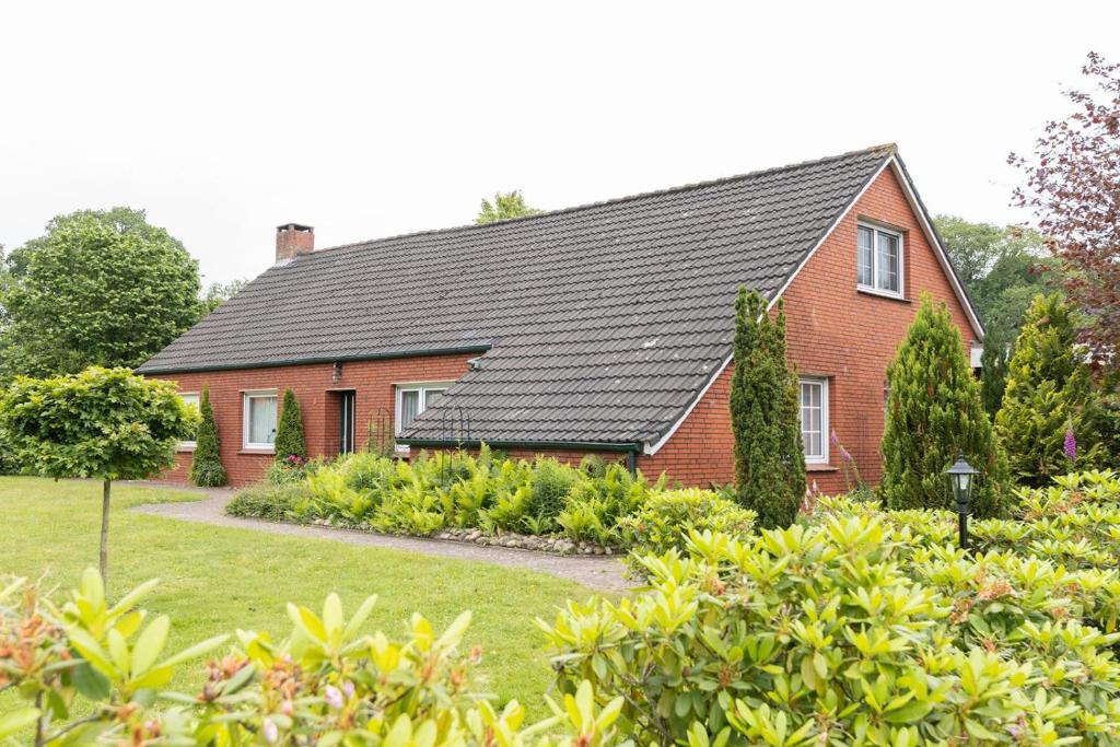 a red brick house with a black roof at Ferienwohnung Mientje, 35214 in Hesel