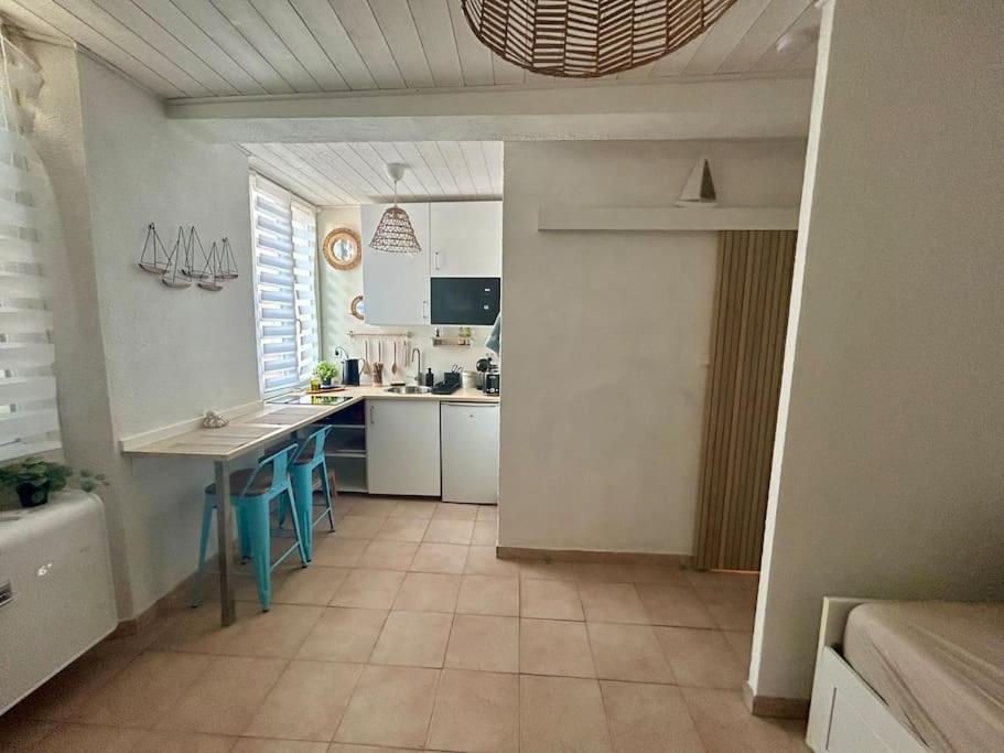 - une cuisine avec une table et un comptoir dans une pièce dans l'établissement Charmant Studio Climatisé au Mourillon, à Toulon