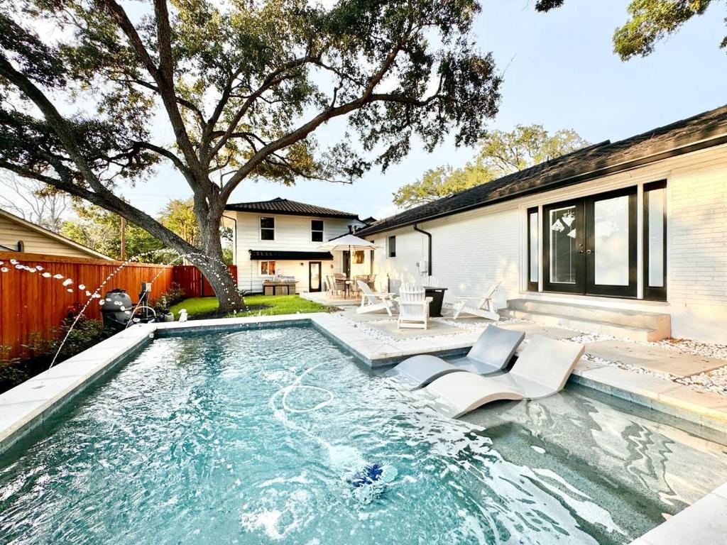 a swimming pool with chairs and a house at Casa Blanca Estate Lux 5BR4BA in San Antonio