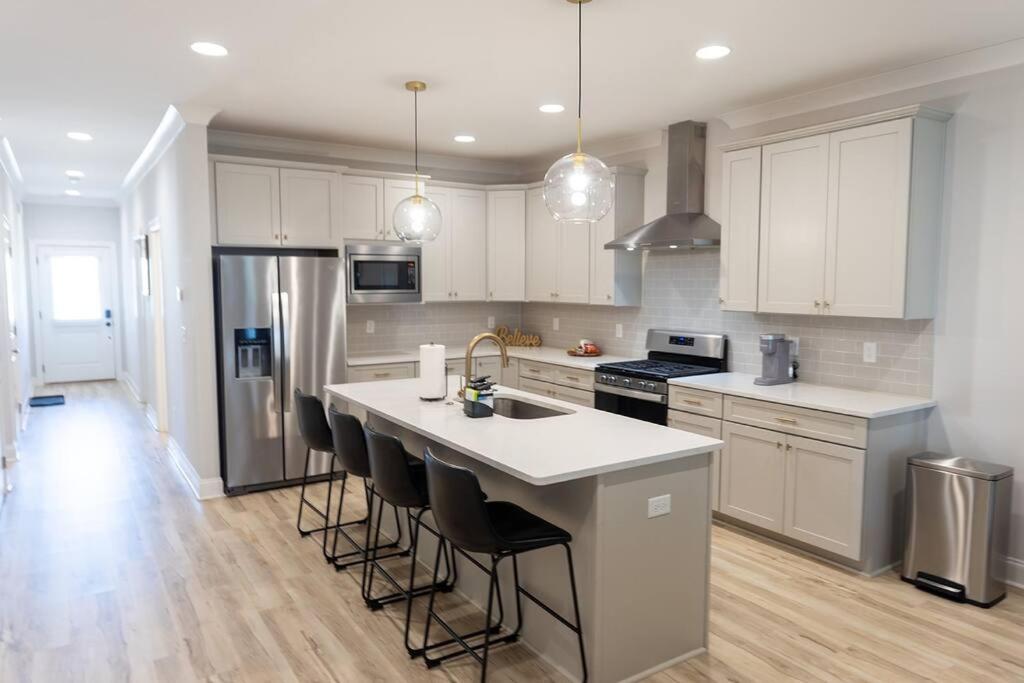 a kitchen with white cabinets and a large island with bar stools at Auburn Family Oasis 3 Bedrooms 3 Bathrooms in Auburn