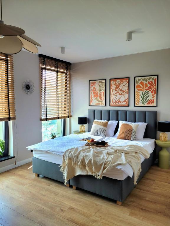 a bedroom with a large bed in a room with windows at Apartamenty K17 Stare Miasto in Malbork