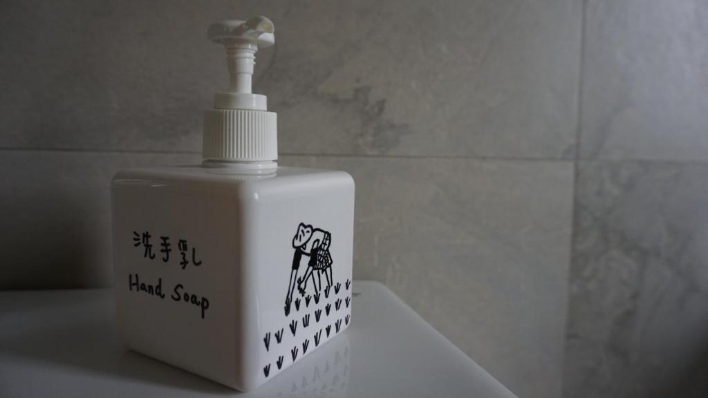 a white bottle of liquid soap sitting on a sink at LivingGreen B&amp;B in Luodong