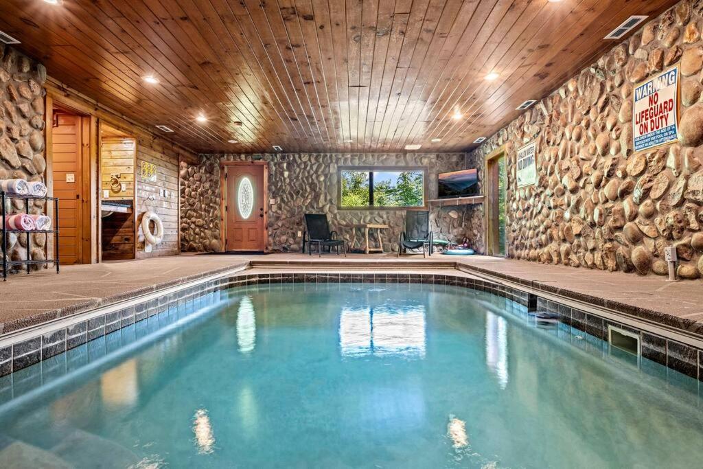 a swimming pool in a home with a stone wall at Pvt Pool at The Grotto in Sevierville