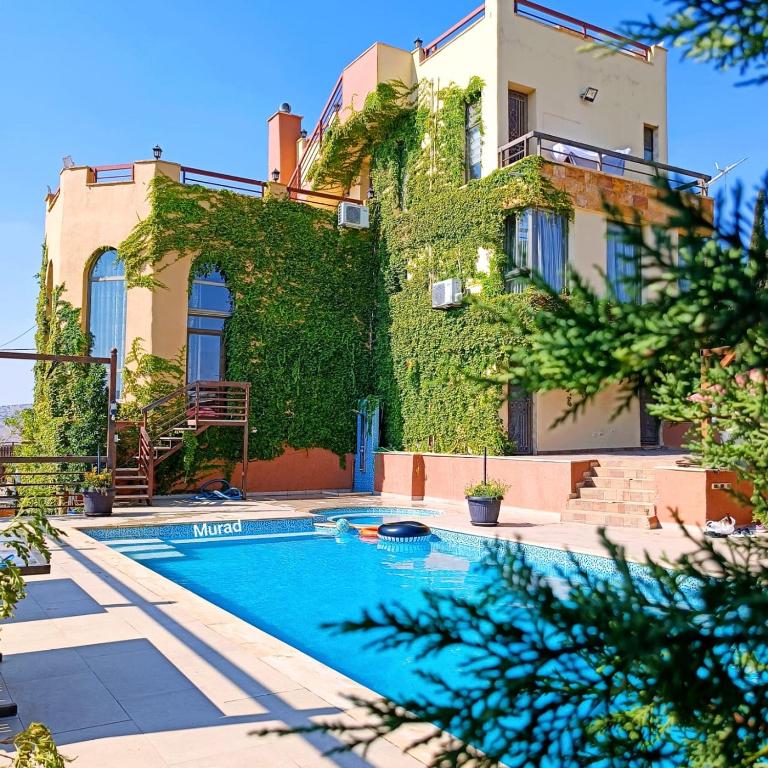 a house with a swimming pool in front of a building at Sultana Farm - Private Pool Villa near Amman in Bayyūḑah
