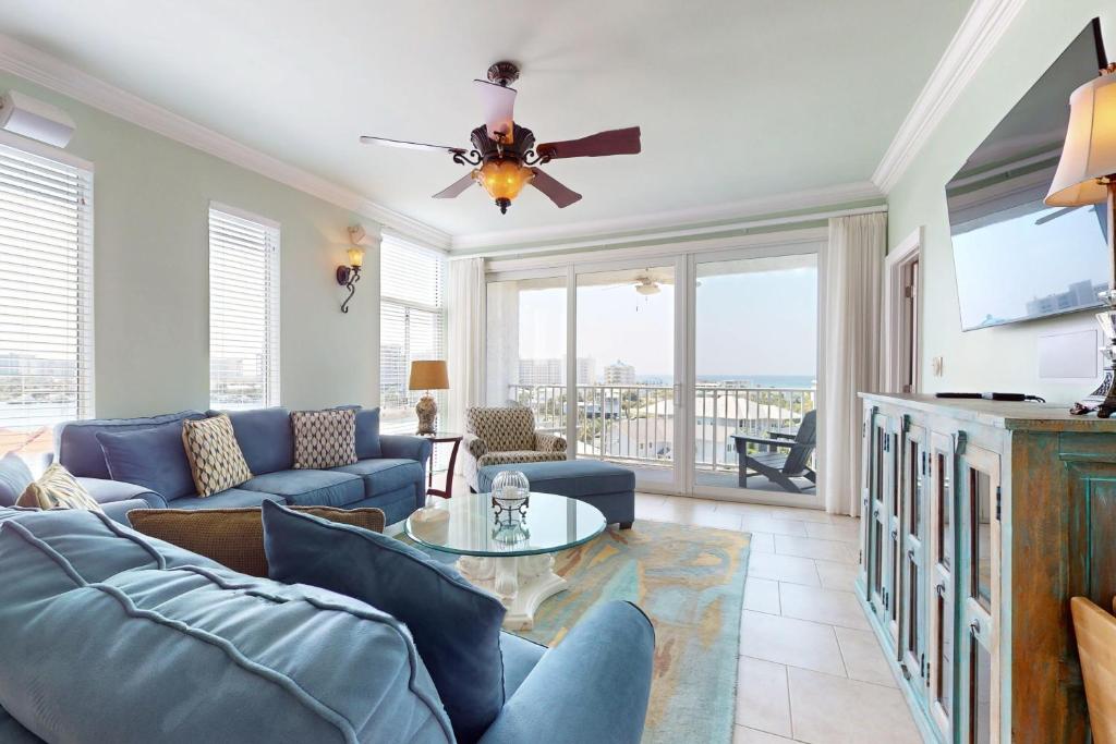Una sala de estar con un sofá y un ventilador de techo. en Dolphin Point 702A, en Destin