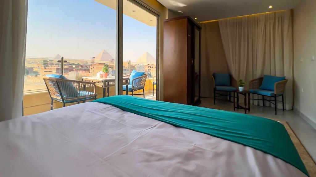 カイロにあるDiamond Pyramids View Innの大きなベッドと大きな窓のある寝室