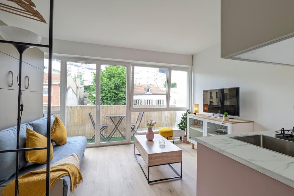un salon avec un canapé bleu et une cuisine dans l'établissement Appartement cosy à Paris, à Puteaux