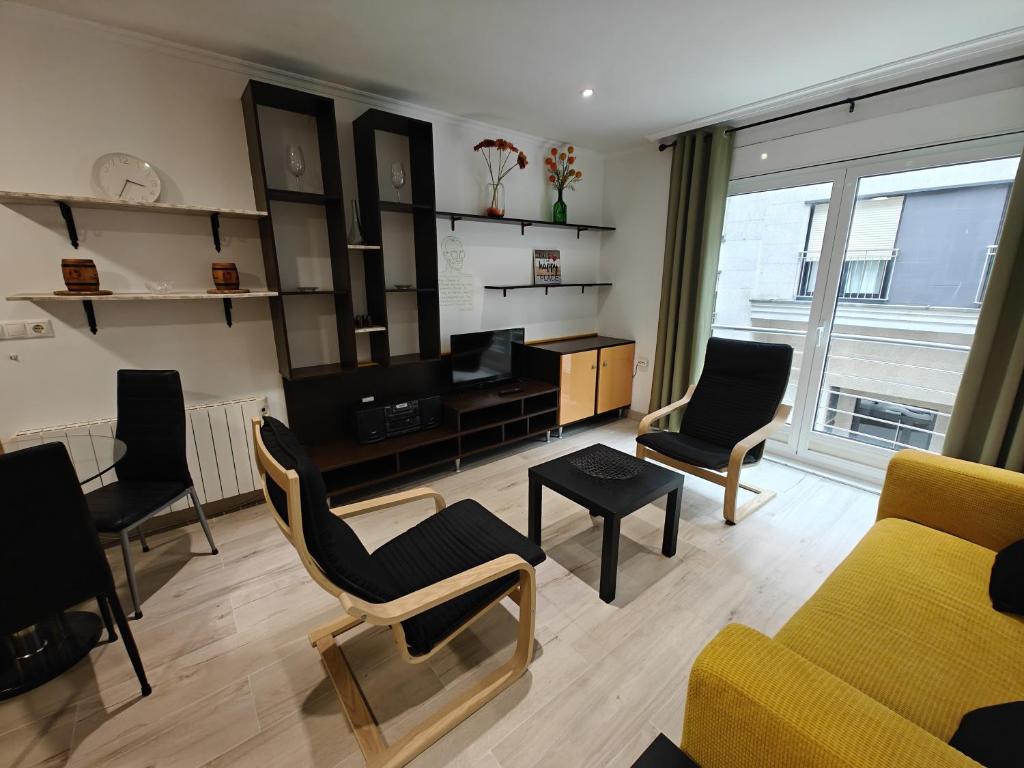 ein Wohnzimmer mit Sofa, Sesseln und Fernseher in der Unterkunft Apartamento en Ribeira in Ribeira