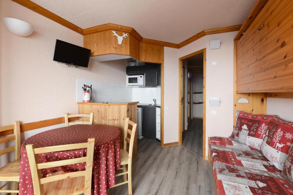 une cuisine et une salle à manger avec une table et un canapé dans l'établissement Résidence Chamois - Studio pour 4 Personnes 134, à La Plagne Tarentaise