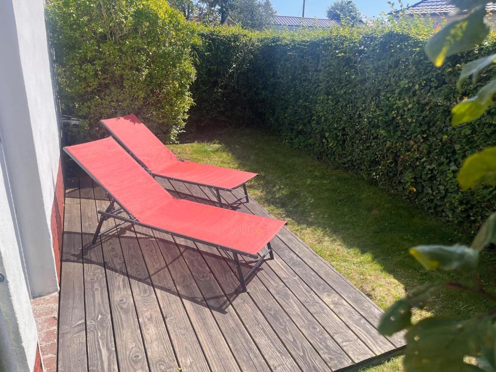 フォール・マオン・プラージュにあるMaison de campagne au bord de la merの木製デッキに座る赤い椅子2脚
