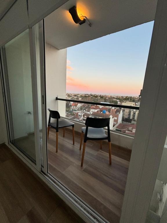 einen Balkon mit 2 Stühlen und Stadtblick in der Unterkunft Vista al horizonte in Mariano J. Haedo