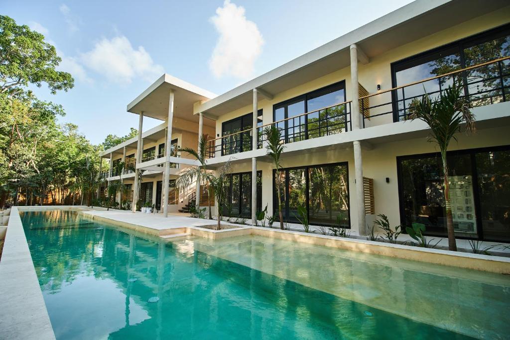 a house with a swimming pool in front of a building at BT Homes - Wellness Jungle in Tulum